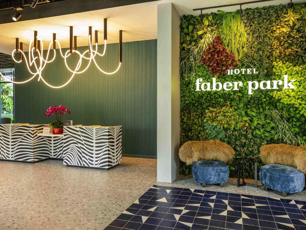 Un vestíbulo de un hotel Fuller Park con una pared con plantas. en Hotel Faber Park Singapore - Handwritten Collection, en Singapur