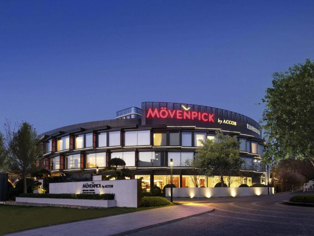 a building with a sign on the front of it at Movenpick by Accor Qingdao Sunmei in Qingdao