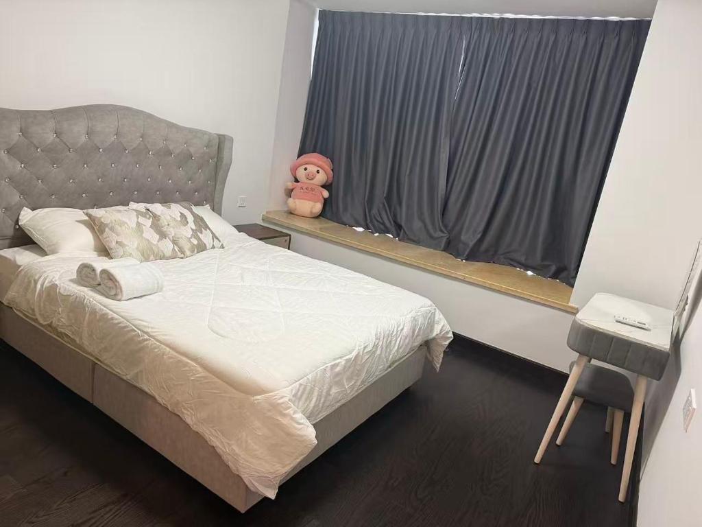 - une chambre avec un lit et une fenêtre avec un ours en peluche dans l'établissement R&F Seine Region, à Gua Sai