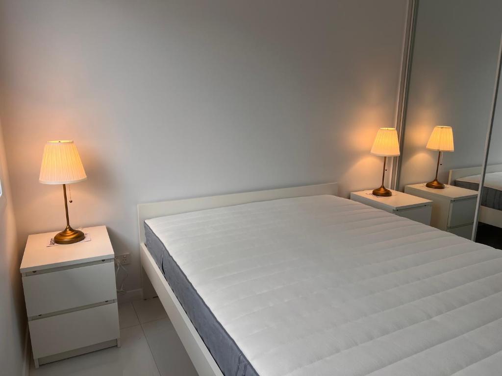 ein Schlafzimmer mit einem großen weißen Bett mit zwei Lampen in der Unterkunft North Parrramatta, NSW 2151 in Sydney