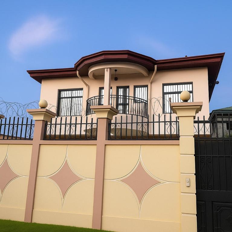 a house with a gate and a fence at Ste Raphaelle Guest House in Yaoundé