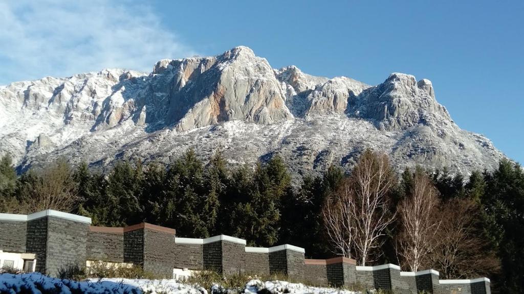 une montagne enneigée devant un bâtiment dans l'établissement Chalets et Gites du Quié, aux Cabannes