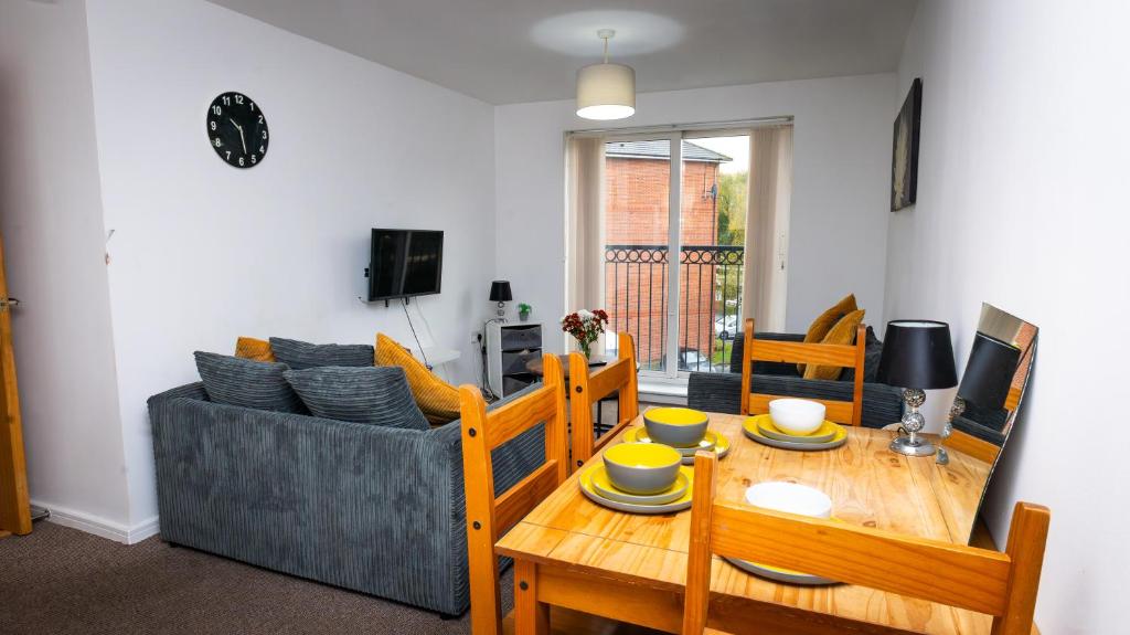 un salon avec une table et un canapé dans l'établissement Greenings Apt Warrington - 2 Bed with FREE off road Parking & Wifi, à Warrington