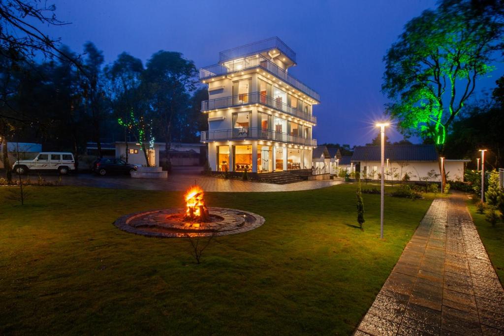 a building with a fountain in front of it at night at Cardamom Village Hill Resort by EGH in Thekkady