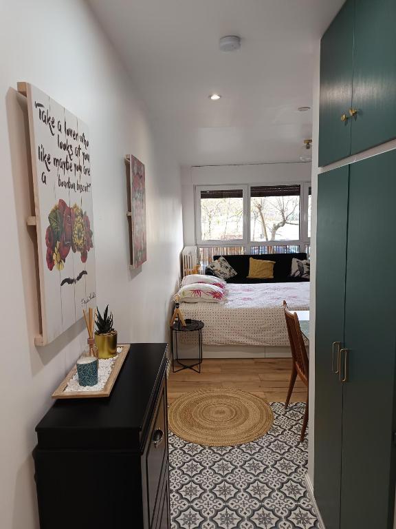 a bedroom with a bed and a room with a table at Le studio Amos in Metz