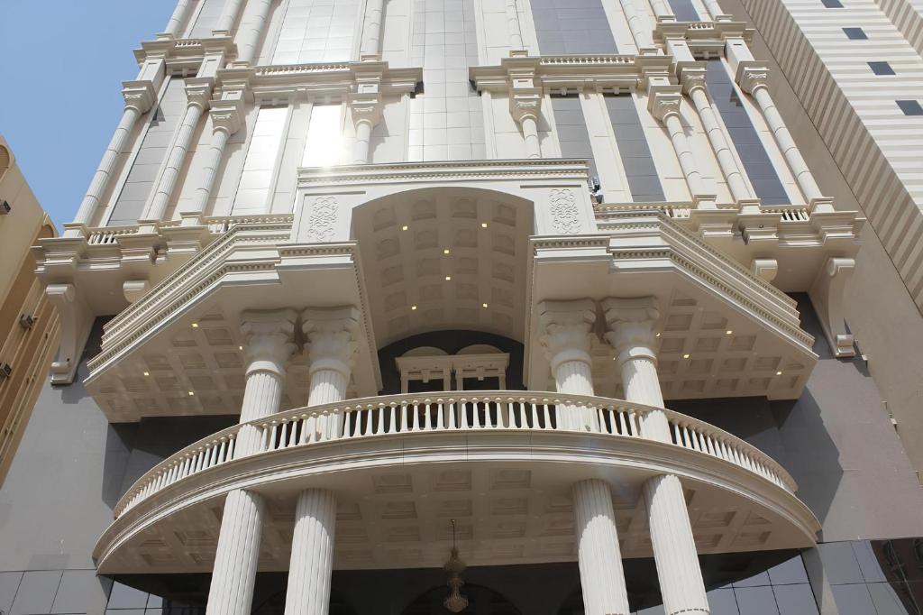 un edificio alto con colonne bianche e un balcone di فندق رهف مكة Rahaf Hotel Maka a Al Khansāk