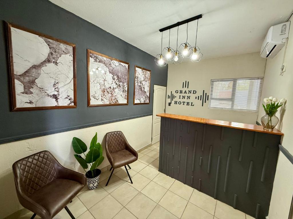 ein Wartezimmer mit zwei Stühlen und einer Theke in der Unterkunft Grand Inn Hotel-Venda in Thohoyandou