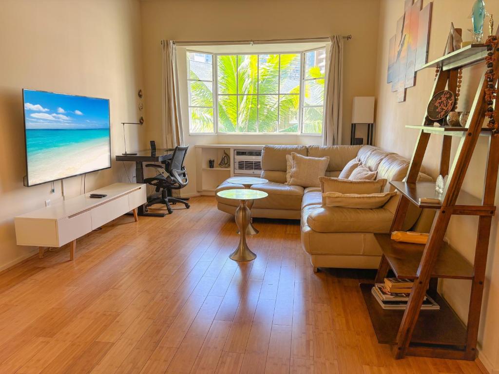 ein Wohnzimmer mit Couch und Flachbildfernseher in der Unterkunft Hawaii Oasis 2-Bedroom at The Cove Waikiki condo in Honolulu