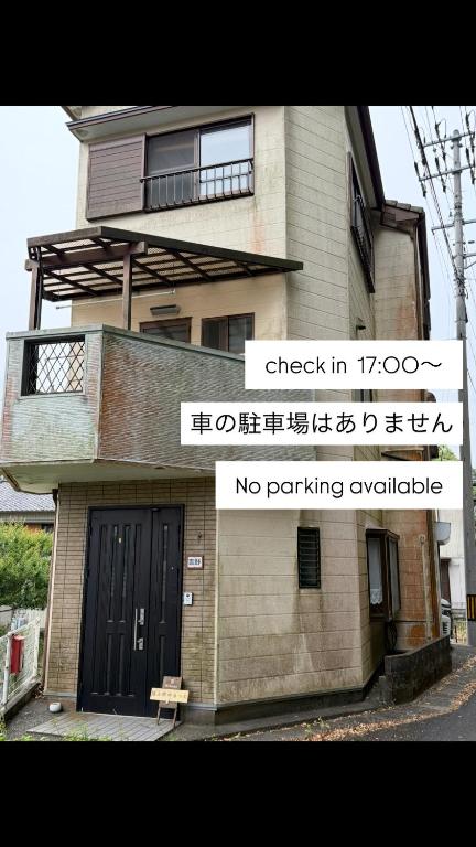 a building with a sign that says check in and no parking vehicles at Guest house 旅人宿ゆるっと in Iburi