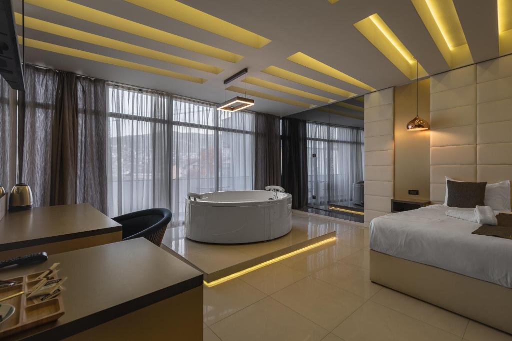 a room with a bed and a bath tub in it at International Palace in Veles