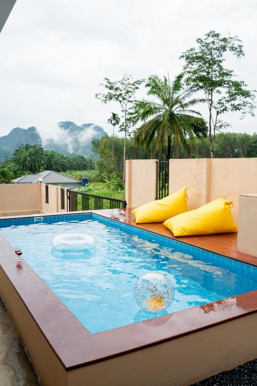 a swimming pool with yellow pillows on top of a building at Wow Mountain Pool Villa Aonang in Ban Nong Thale