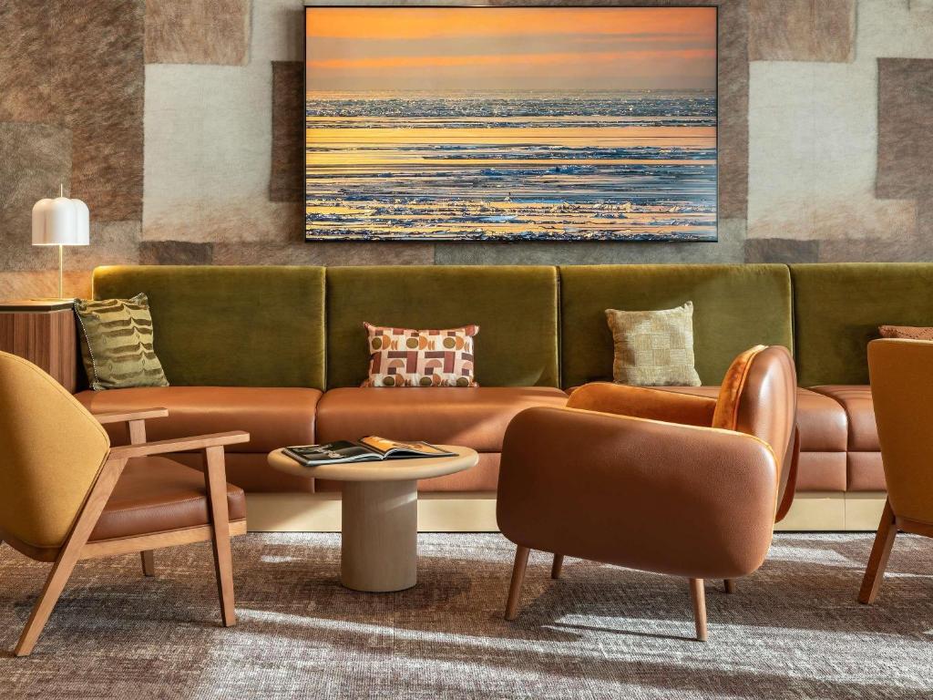 a living room with a couch and chairs at Novotel Paris La Défense Nanterre in Nanterre