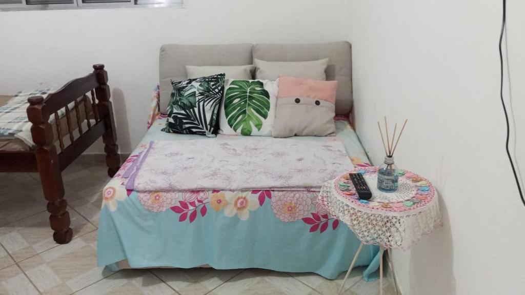 a bed with pillows and a table in a room at Refúgio em São Paulo in Sao Paulo