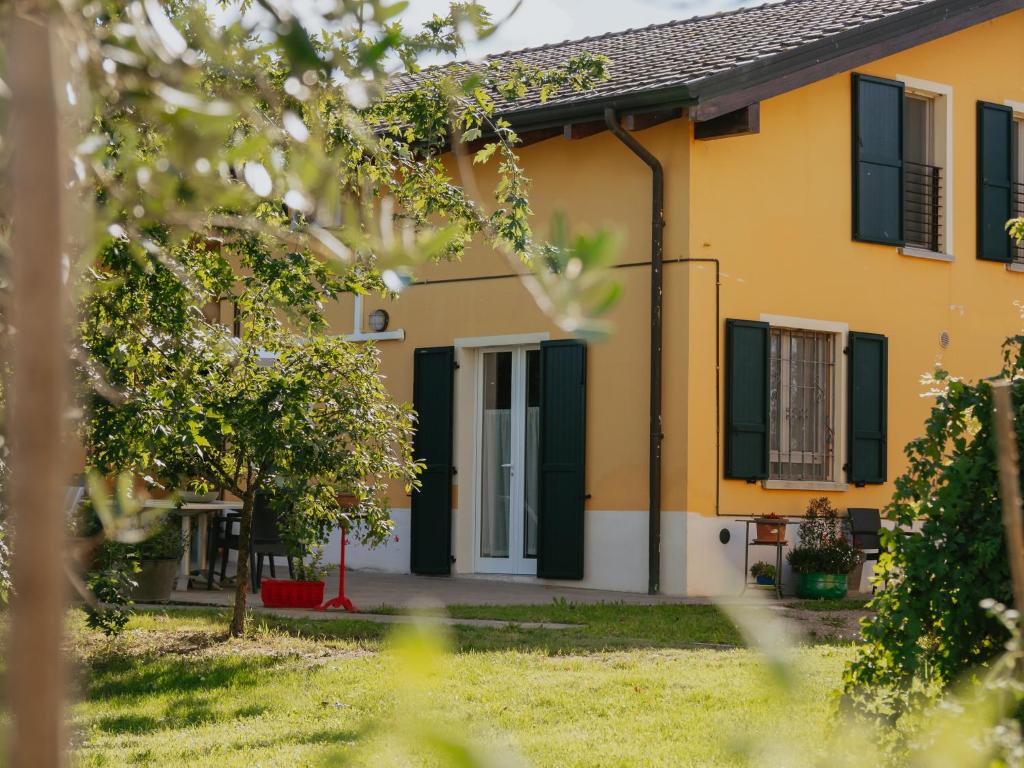 Casa Roberta - Esperienze di campagna في ريجيو إيميليا: منزل أصفر مع مصاريع خضراء
