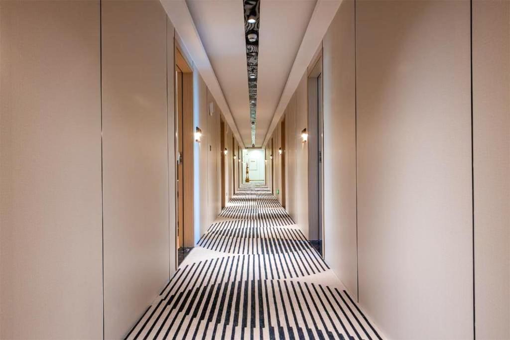 a corridor of a building with black and white stripes at UPTO Hotel in Xiamen