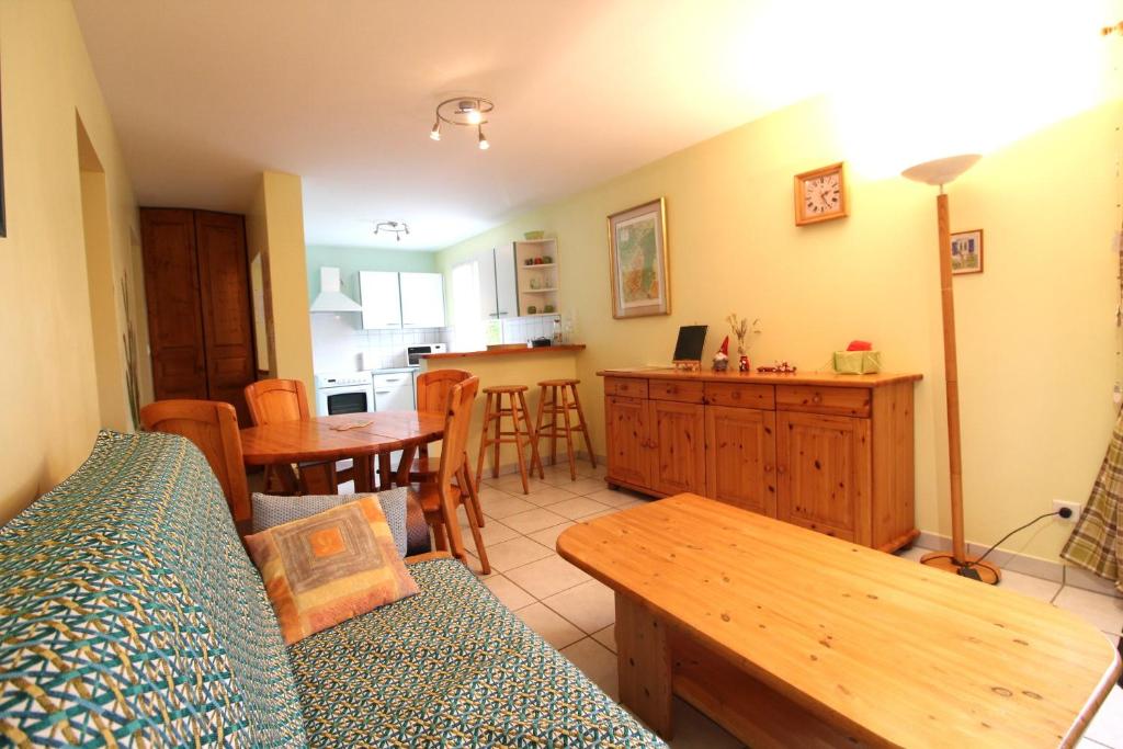 un salon avec un canapé et une table dans l'établissement Appartement Le Chalet Vert proche lac randonnées, à La Bresse