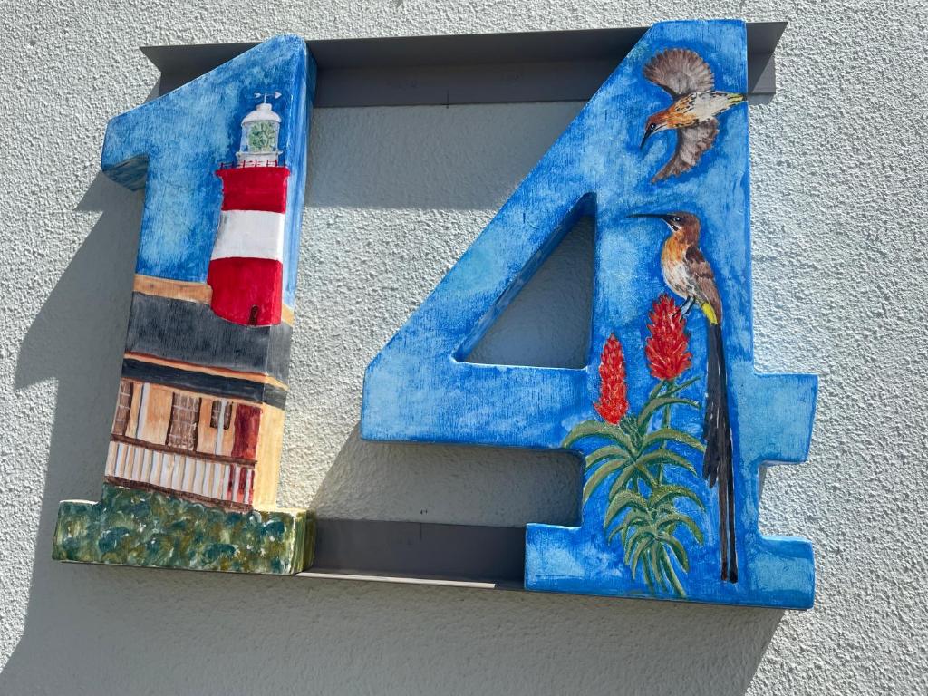 Un número cuatro azul con un faro y un pájaro. en Coast B&B - Agulhas, en Agulhas