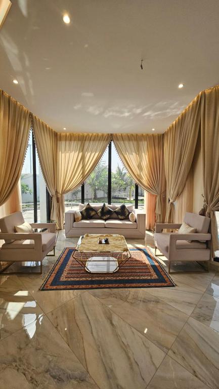 un ampio soggiorno con divani e un tavolo di استراحة الزهراء a Gedda