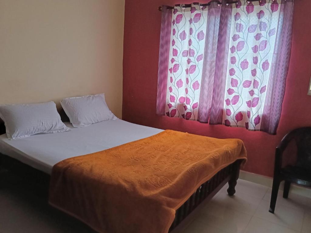 a bed in a bedroom with pink curtains at Coorg villas & homes in Madikeri