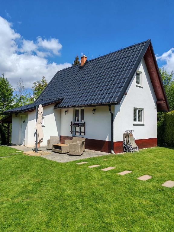 a white house with a statue in the yard at Wellness chata BABÍ VRCH in Trojanovice