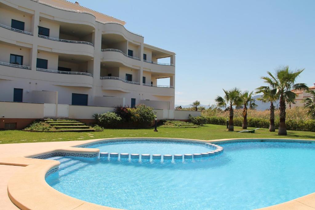 a swimming pool in front of a building at Las Olas Denia in Denia