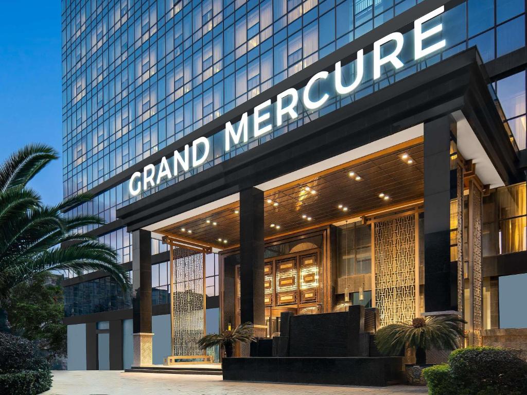 un bâtiment avec une enseigne indiquant Grand Mcenter dans l'établissement Grand Mercure Kunming South, à Kunming