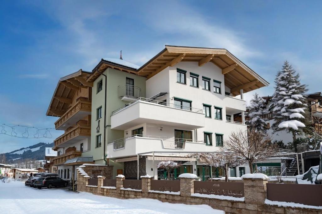 a large apartment building with snow on the ground at Hotel Gänsleit in Söll