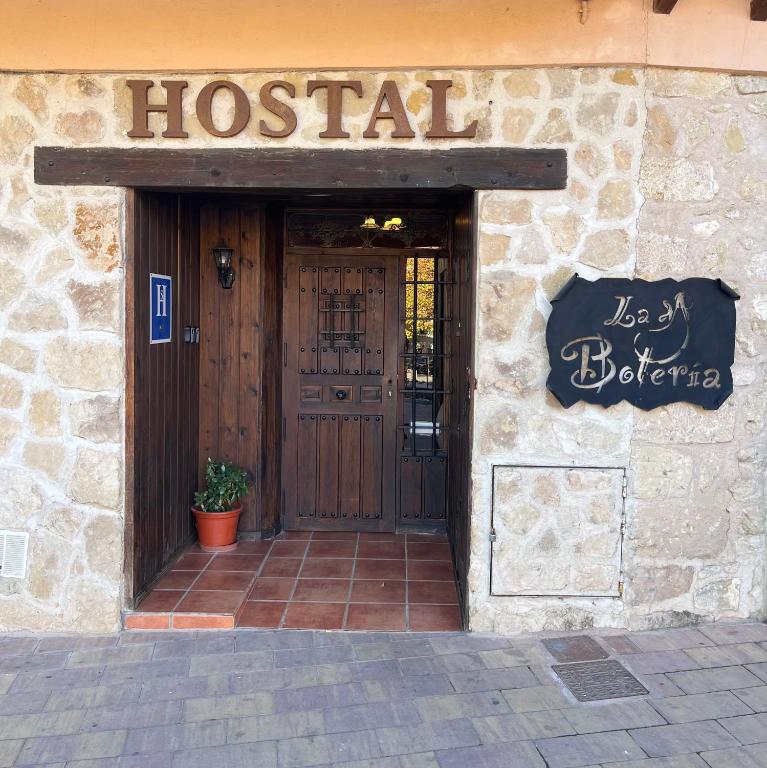 a hospital building with a door with a sign on it at Hostal Rural La Botería in Sacedón
