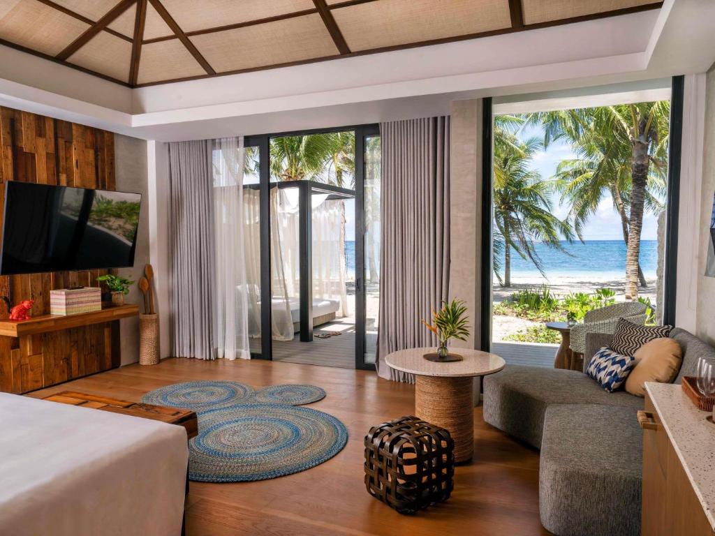 a hotel room with a bed and a view of the ocean at South Palms Resort and Spa Panglao - MGallery Collection in Panglao