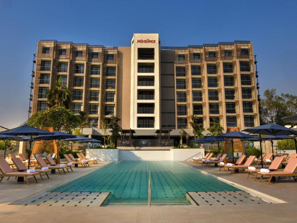 a hotel with a swimming pool in front of a building at Mövenpick Kigali in Kigali