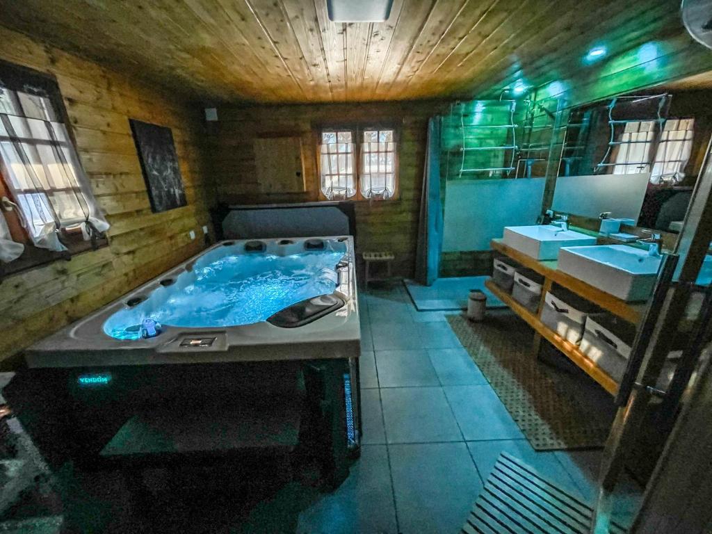 a large bathroom with a tub and a sink at gîte avec spa, sauna et piscine in Le Thillot