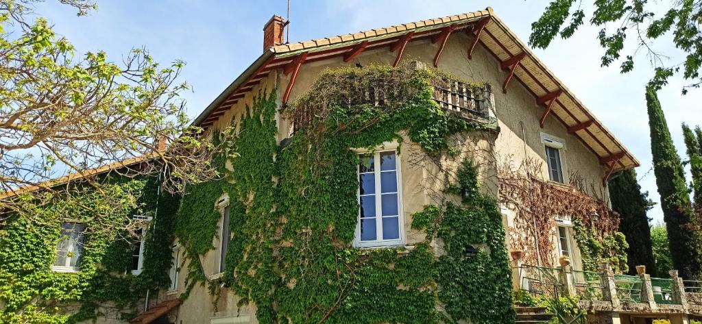 an ivy covered building with a window on the side at Chambre d'hôtes Park des Collines - Gîte in Génissieux