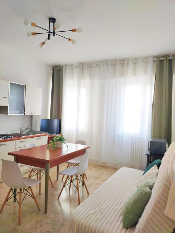 a living room with a table and a couch and a kitchen at Trilocale vacanza Riccione in Riccione