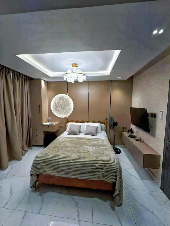 a bedroom with a large bed and a television at Double Bed with balcony in Lagos