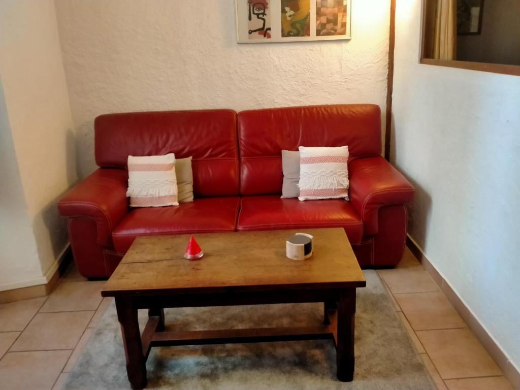 un divano rosso in un soggiorno con un tavolino da caffè di Logement au cœur de lorgues a Lorgues
