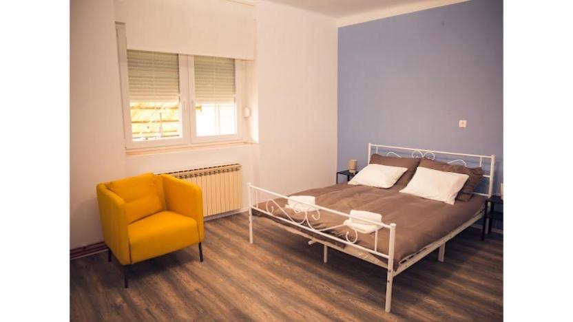 une chambre avec un lit et une chaise jaune dans l'établissement Pro-Apartments Croatia, à Varaždinske Toplice