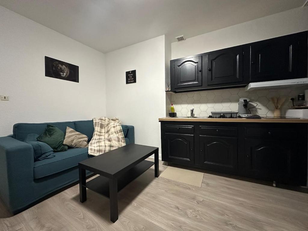 Una sala de estar con un sofá azul y una mesa. en Le Cocon Cathédrale, en Metz