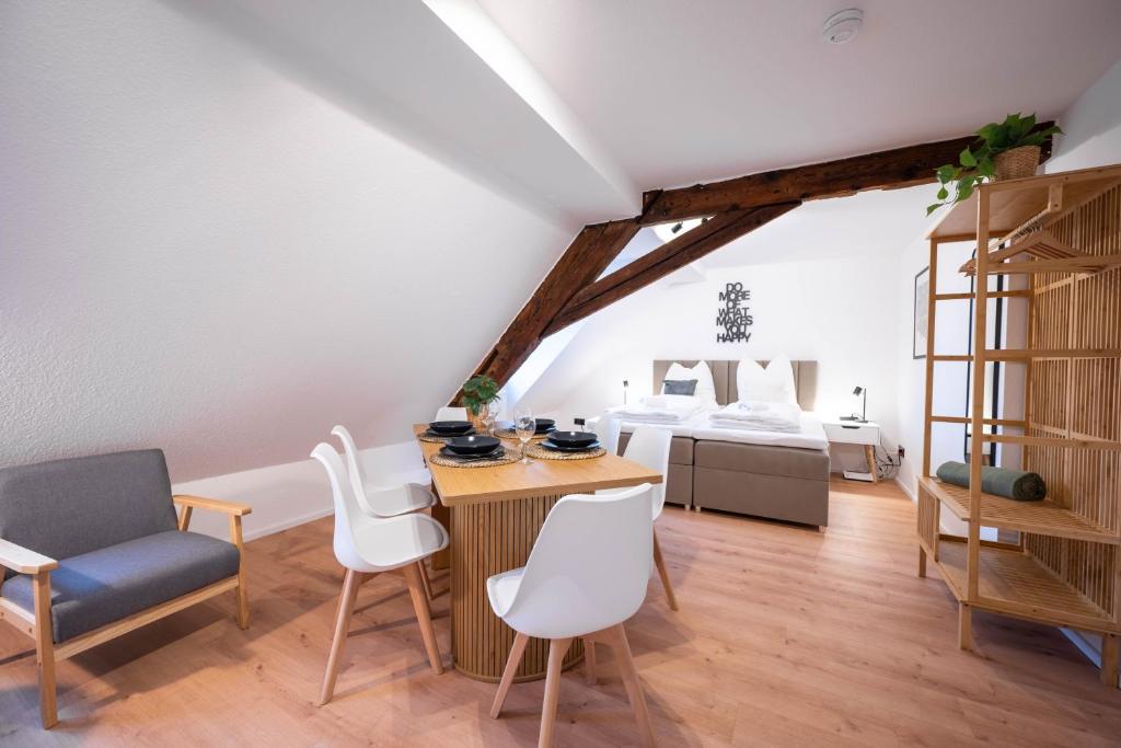 a room with a table and chairs and a bed at LudwigsCozyEscape - Historisches Altstadt-Apartment mit Sichtbalken am Residenzschloss, 6 Gäste, SmartTV in jedem Zimmer, Highspeed WLAN, Workspace, 24h Self Check-in, Parkhaus 2 Min Gehweite in Ludwigsburg