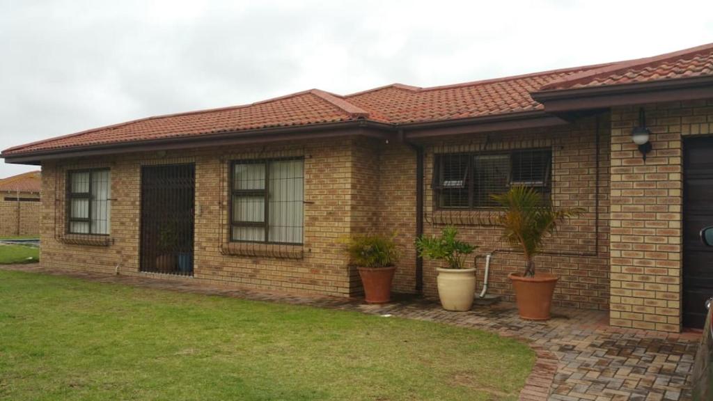 una casa de ladrillo con macetas delante de ella en Amery Villa, en Gqeberha