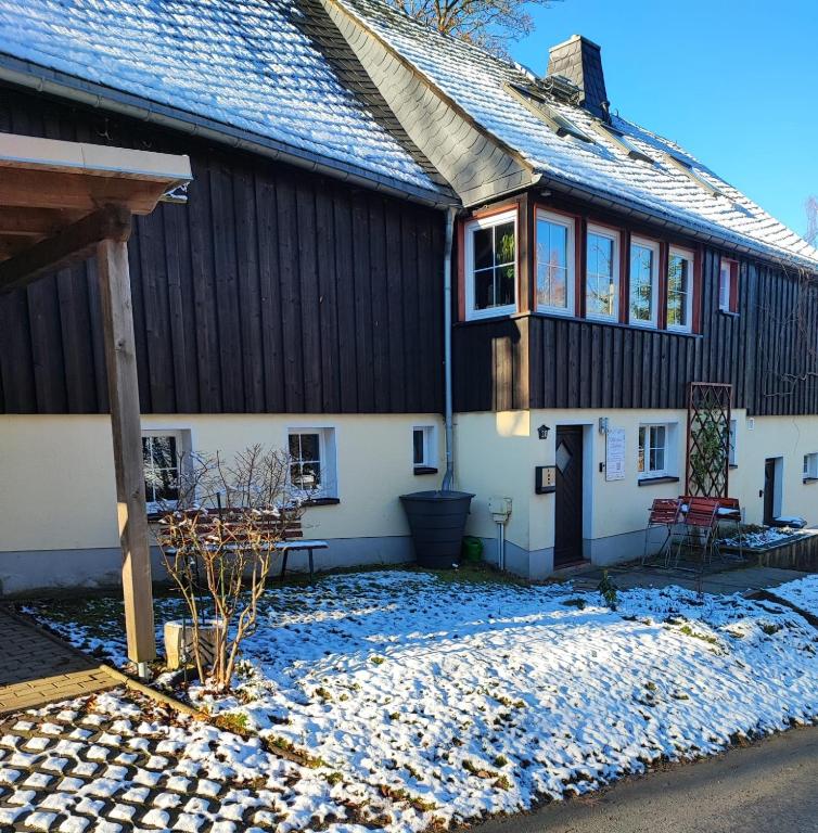 a house with snow on the ground in front of it at Marthas Stübchen in Kurort Altenberg