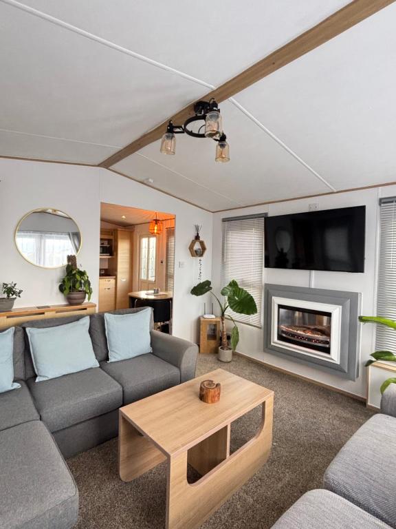 a living room with a couch and a fireplace at Seven Bays Hideaway in St Merryn