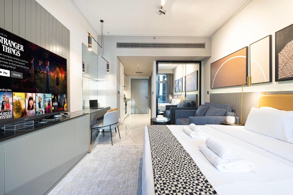 迪拜Cosy Studio, 7-min walk Burj Khalifa and Dubai Mall的一间带大床的卧室和一间客厅