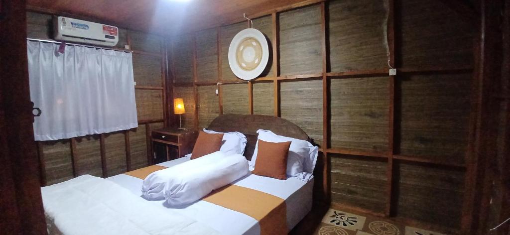 - une chambre avec 2 lits dans une pièce en bois dans l'établissement Villa Ilham Ketembong, à Tetebatu