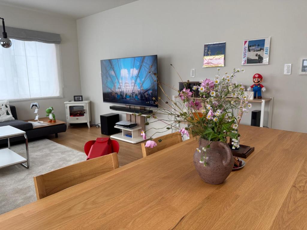 a living room with a vase of flowers on a table at Mori Sapporo in Sapporo