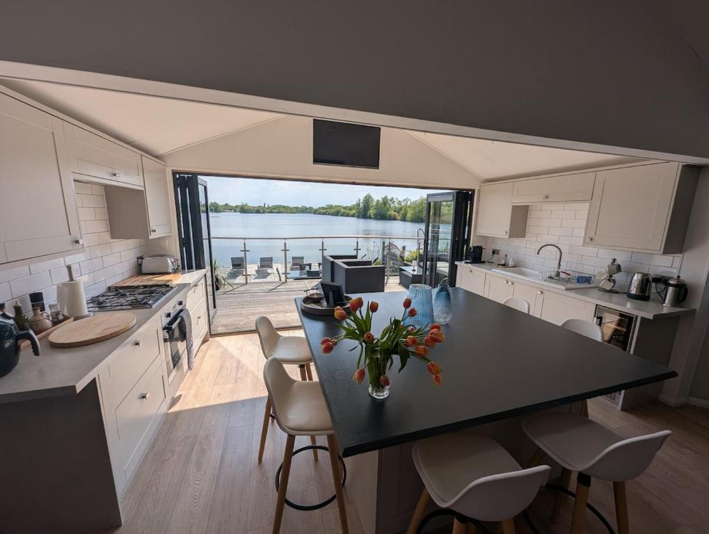 une cuisine avec une table avec un vase de fleurs dessus dans l'établissement The Boathouse Lodge, à Whelford