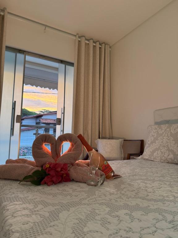 two stuffed swans sitting on top of a bed at Casa completa e climatizada em Ilhéus in Ilhéus