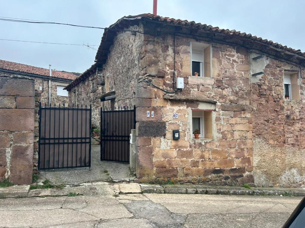 an old stone building with two gates on it at Casa Rural en BRAÑOSERA in Brañosera