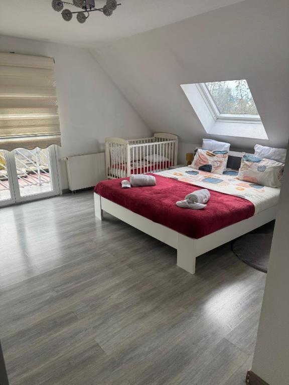 a bedroom with a large bed with a red blanket at Au petit Logelbach in Wintzenheim