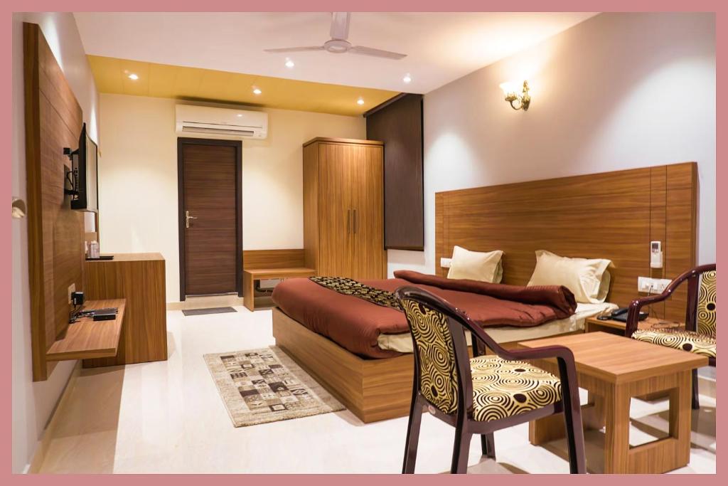 a bedroom with a bed and a desk and a table at Vidyalaxmi Narayan marg Sagar Chandrodaya Varindavan Near Shree Hanuman Tekri Temple and Bankey Bihari Temple - Free Public Parking and Room Service - Fully Air conditioning Luxuary Room - Top Rated Hotel in Vrindāvan