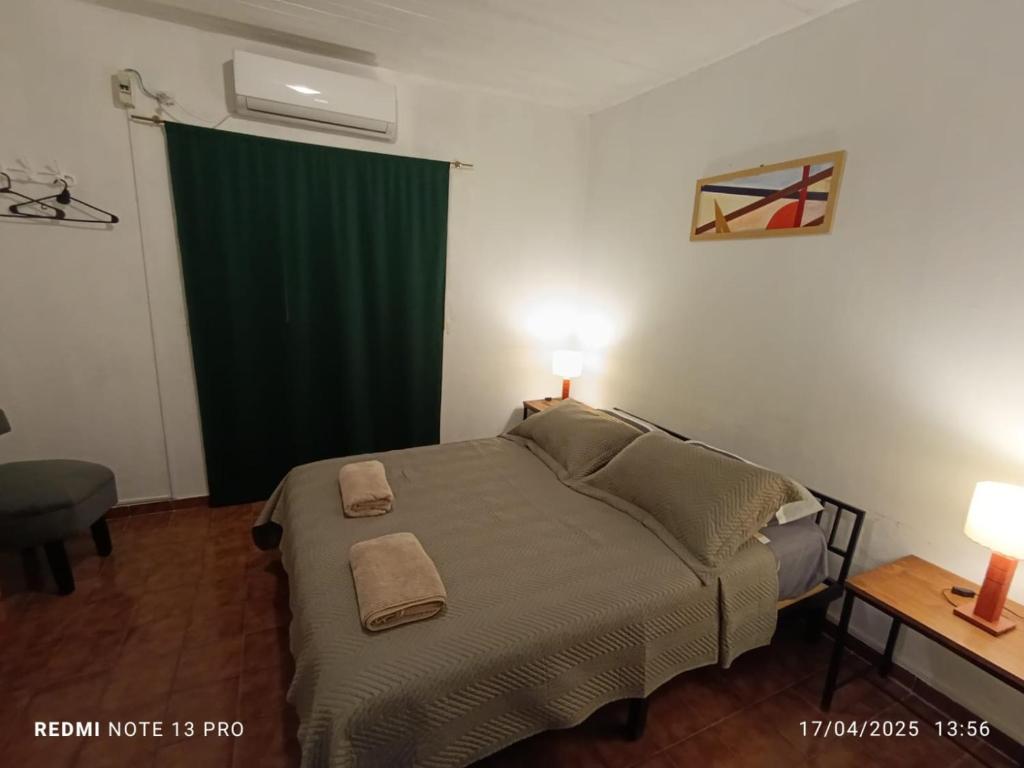a bedroom with a bed and a green curtain at Departamento Céntrico in Oberá